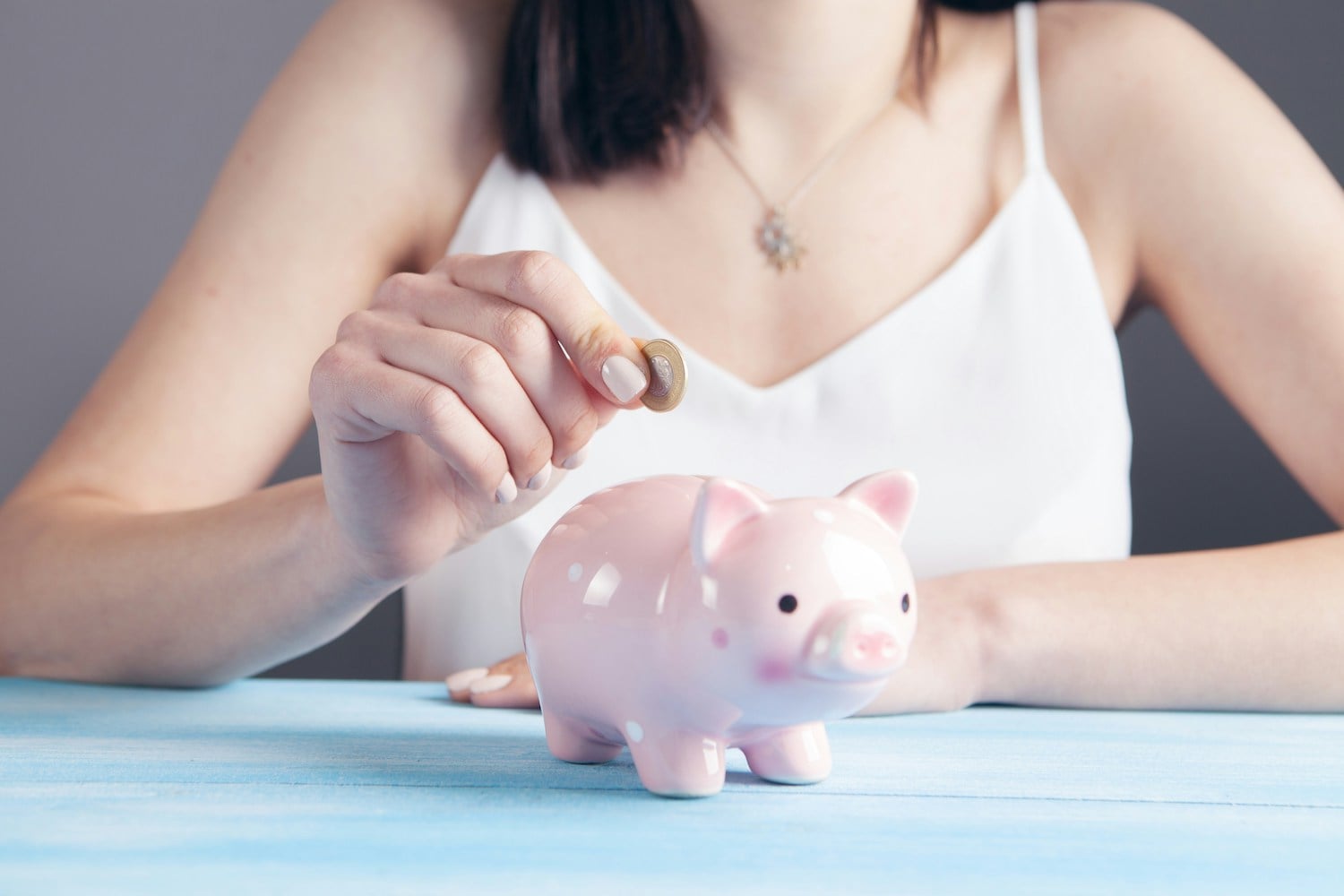 Woman saving money with piggy bank